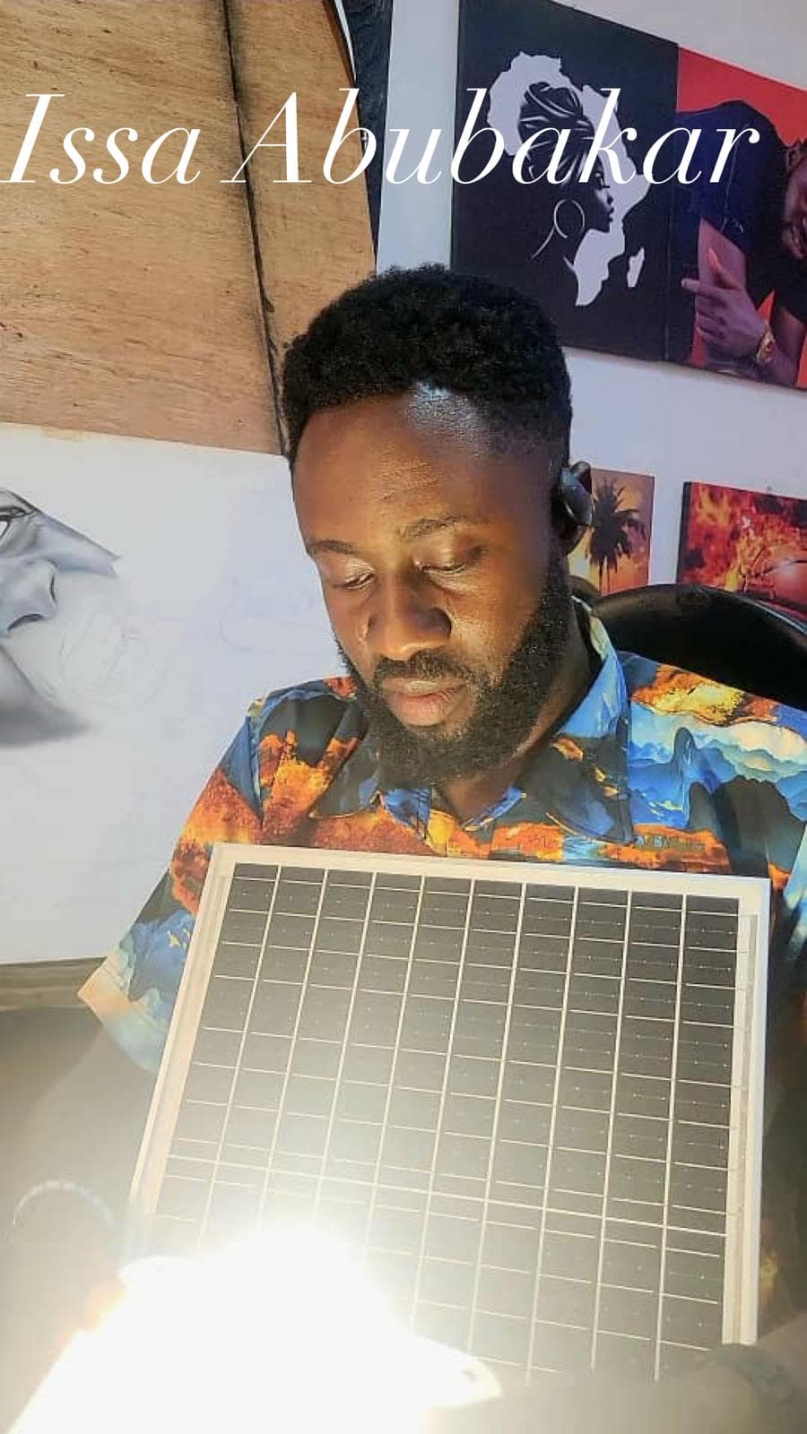 Artist Tssa Abubakar with a Quadloop solar kit and artwork.